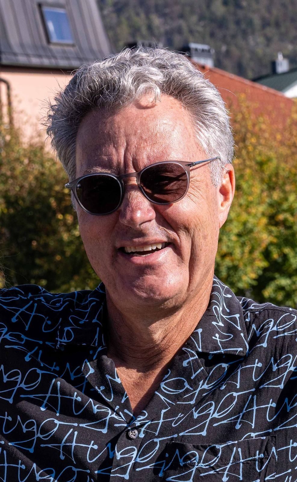 Walter Scamoni lächelt in die Kamera, im Hintergrund Häuser und Bäume